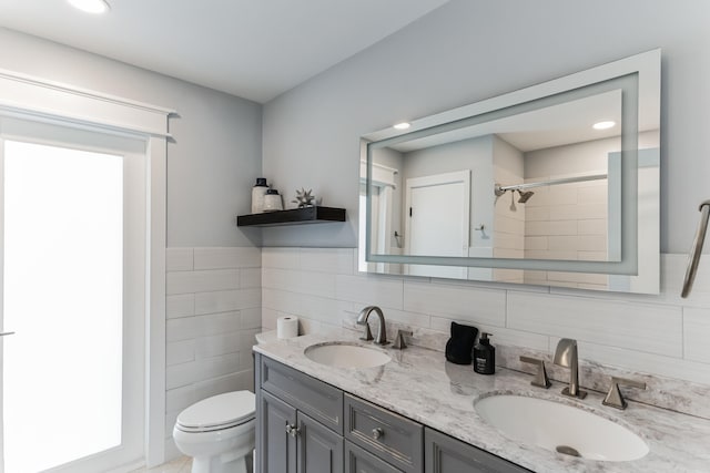 bathroom featuring toilet, walk in shower, vanity, decorative backsplash, and tile walls