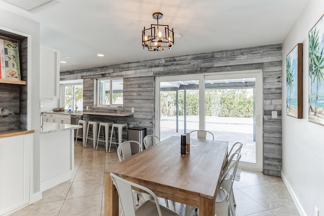 tiled dining area featuring a chandelier and sink