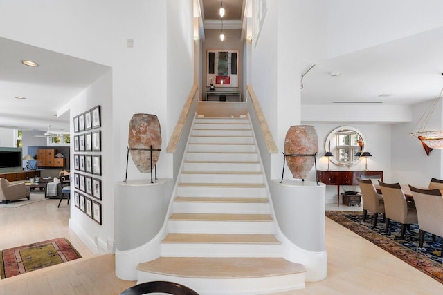 staircase with a healthy amount of sunlight, hardwood / wood-style floors, and ceiling fan