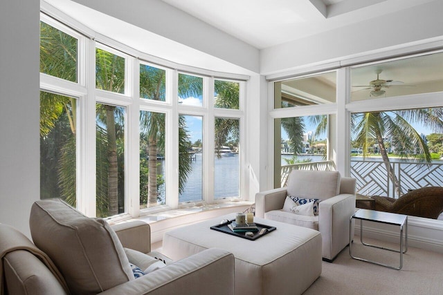 sunroom / solarium featuring ceiling fan and a water view