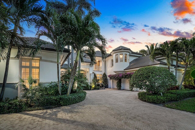 view of front of home featuring a garage, decorative driveway, and stucco siding