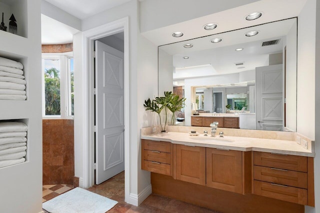 full bathroom featuring walk in shower, vanity, visible vents, and recessed lighting