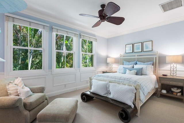 carpeted bedroom featuring crown molding and ceiling fan