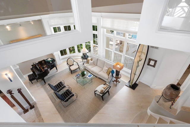 living room featuring a towering ceiling and light hardwood / wood-style floors