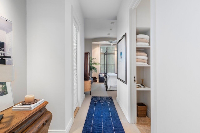 hallway with light colored carpet and a healthy amount of sunlight