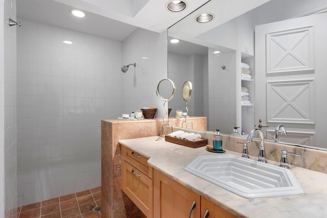 bathroom featuring tiled shower and vanity