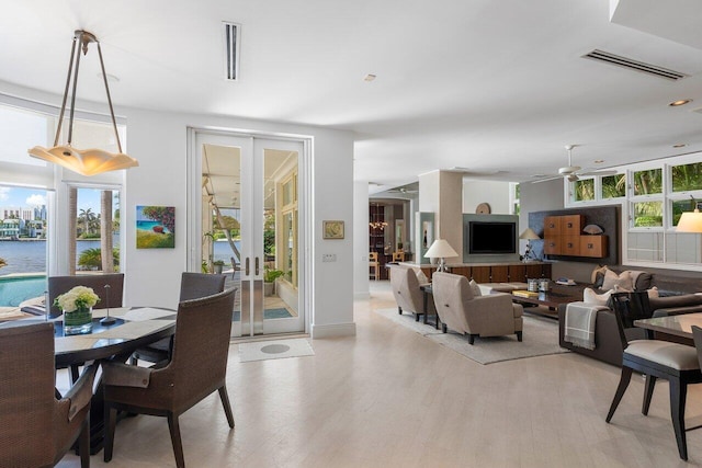 dining area with a ceiling fan, light wood-type flooring, french doors, and visible vents