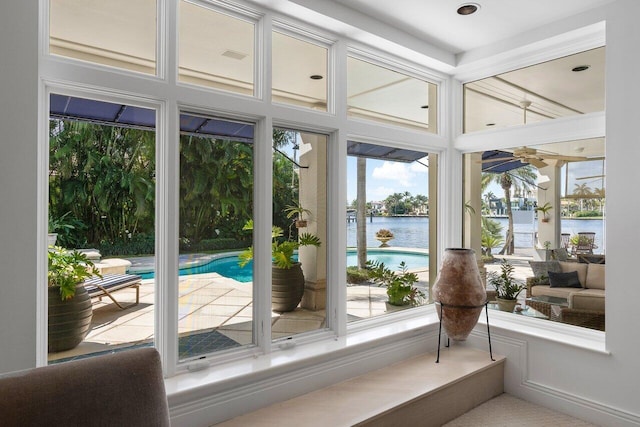 sunroom with a wealth of natural light and a water view