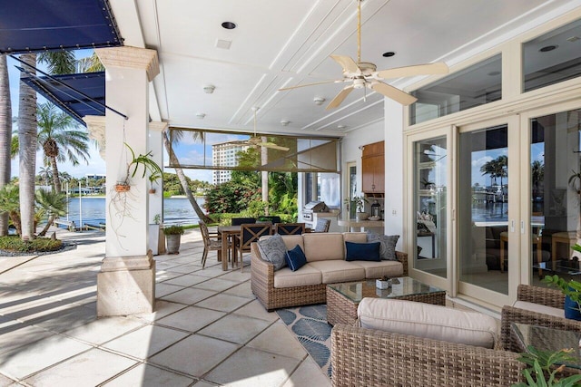 view of patio featuring a water view, outdoor lounge area, and ceiling fan