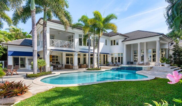 rear view of house featuring a balcony, a patio area, a lawn, and ceiling fan