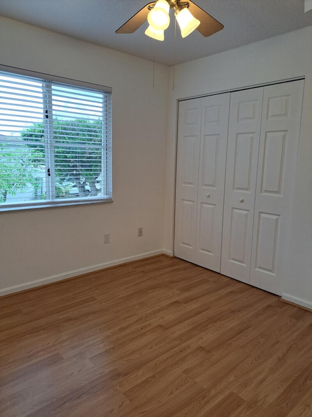 unfurnished bedroom featuring a closet, ceiling fan, and hardwood / wood-style flooring