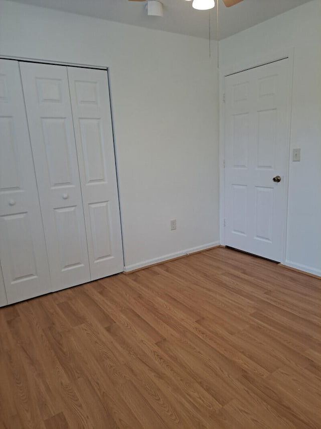 unfurnished bedroom featuring light hardwood / wood-style flooring, ceiling fan, and a closet