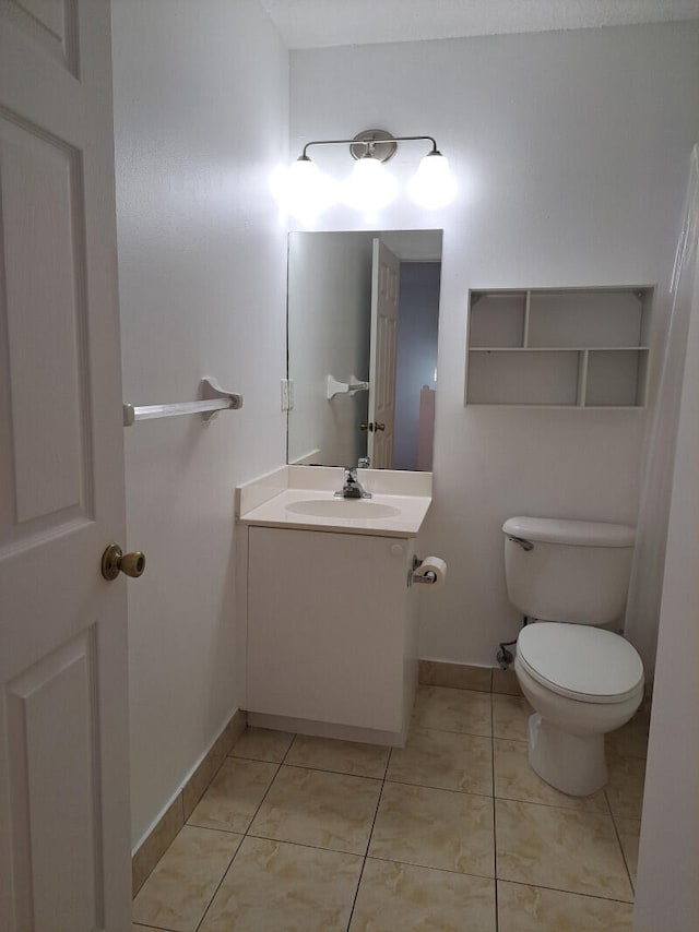 bathroom featuring tile patterned flooring, toilet, and vanity