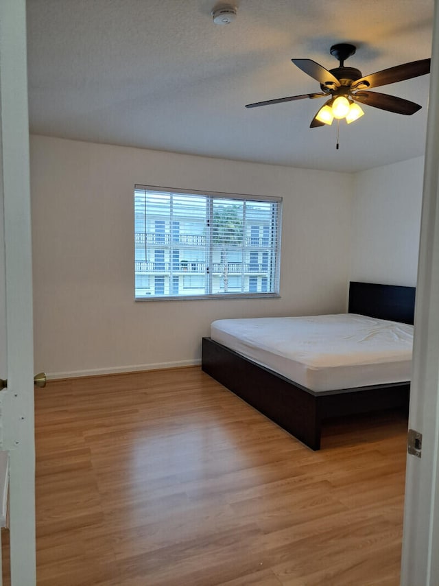 unfurnished bedroom with ceiling fan and hardwood / wood-style floors