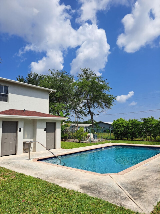 view of swimming pool featuring a lawn and a patio area