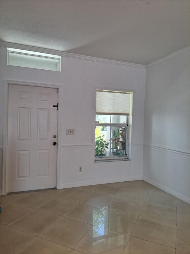 foyer featuring light tile patterned floors and crown molding