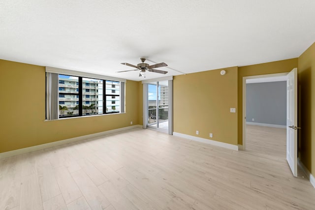 empty room with ceiling fan, a textured ceiling, and light hardwood / wood-style floors