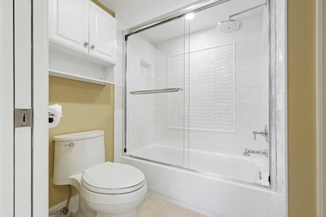 bathroom featuring bath / shower combo with glass door and toilet