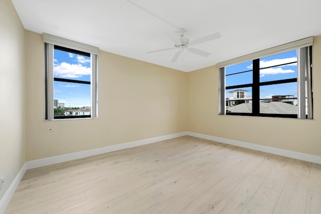 spare room with ceiling fan and light wood-type flooring