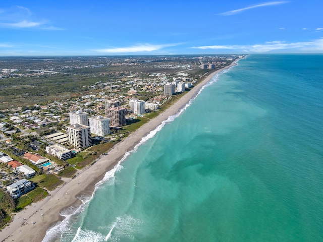 drone / aerial view featuring a beach view and a water view