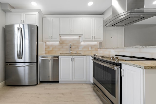 kitchen featuring stainless steel appliances, wall chimney range hood, and white cabinetry