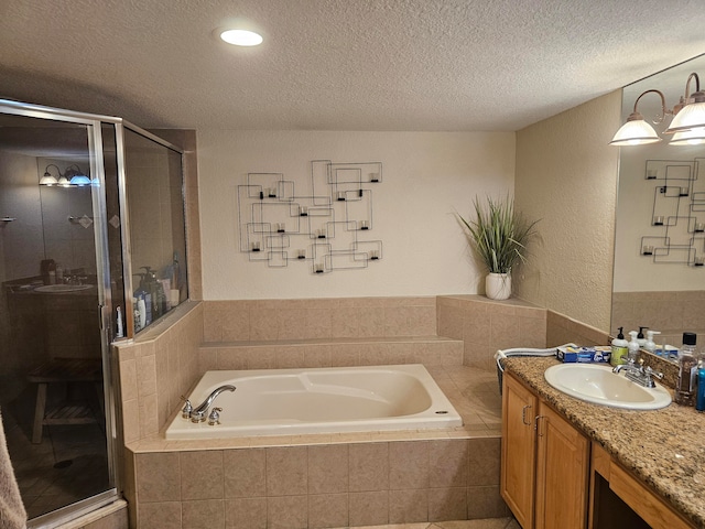 bathroom featuring plus walk in shower, a textured ceiling, and vanity