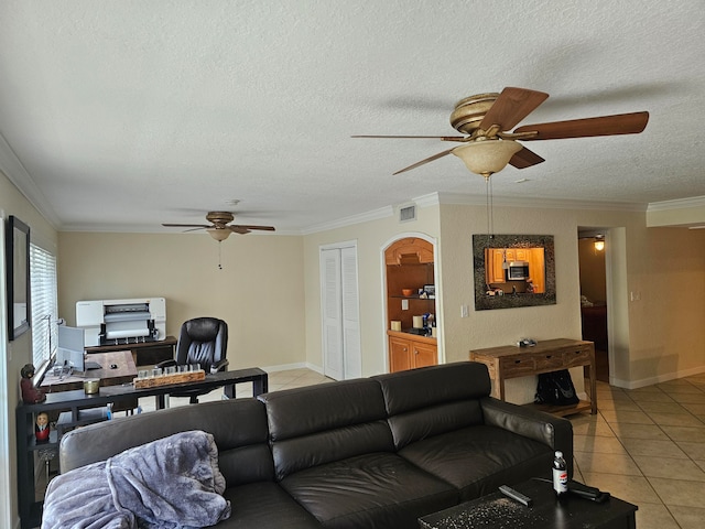 living room featuring ornamental molding, a textured ceiling, light tile patterned floors, and ceiling fan