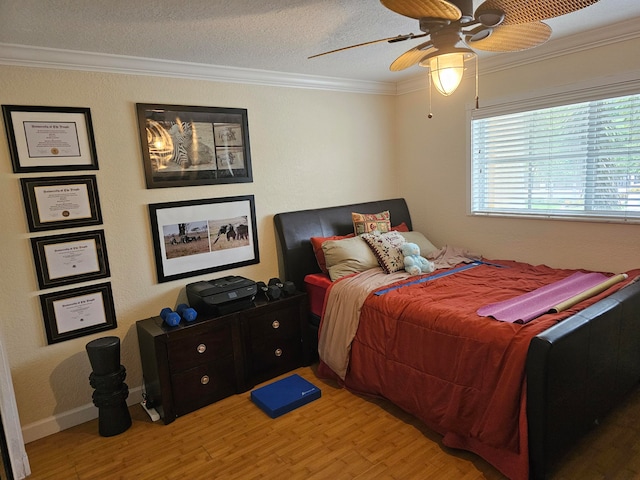 bedroom featuring ceiling fan, ornamental molding, a textured ceiling, and light hardwood / wood-style flooring