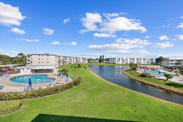 view of swimming pool featuring a water view and a lawn