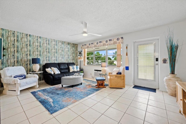 living room featuring ceiling fan, a wall mounted air conditioner, a textured ceiling, and light tile patterned floors