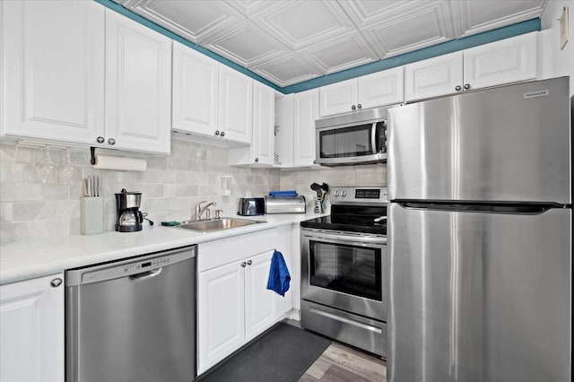 kitchen with stainless steel appliances, sink, and white cabinets