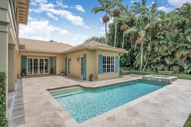 view of pool with a patio area, french doors, and a pool with connected hot tub