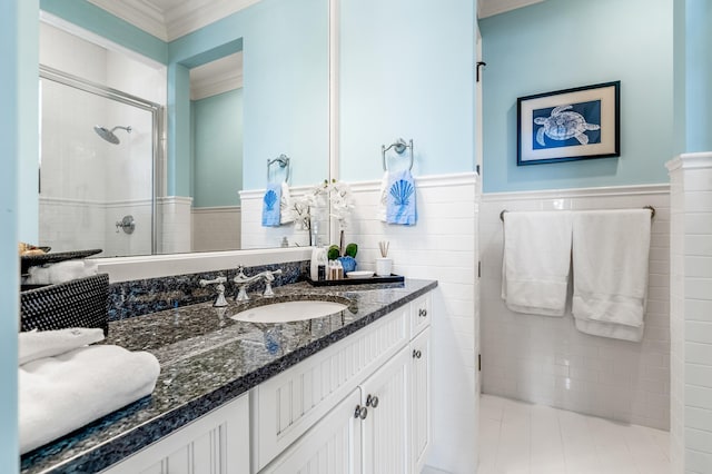 full bath with tile walls, ornamental molding, wainscoting, a stall shower, and vanity