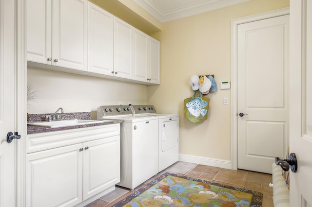 washroom with washer and dryer, a sink, cabinet space, crown molding, and baseboards