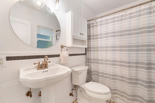 bathroom featuring tile walls, toilet, backsplash, and curtained shower