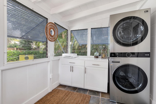 washroom featuring a wealth of natural light, cabinets, and stacked washer and dryer