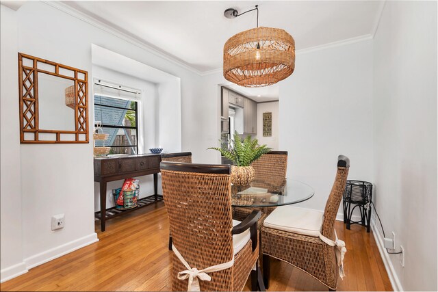 dining space featuring hardwood / wood-style flooring and crown molding