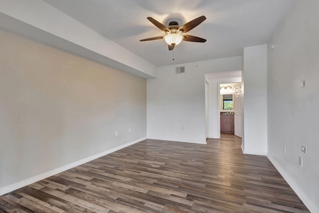 empty room with ceiling fan and dark hardwood / wood-style floors