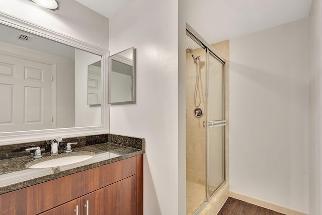 bathroom with a shower with door, vanity, and hardwood / wood-style flooring