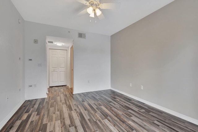 empty room with dark hardwood / wood-style flooring and ceiling fan