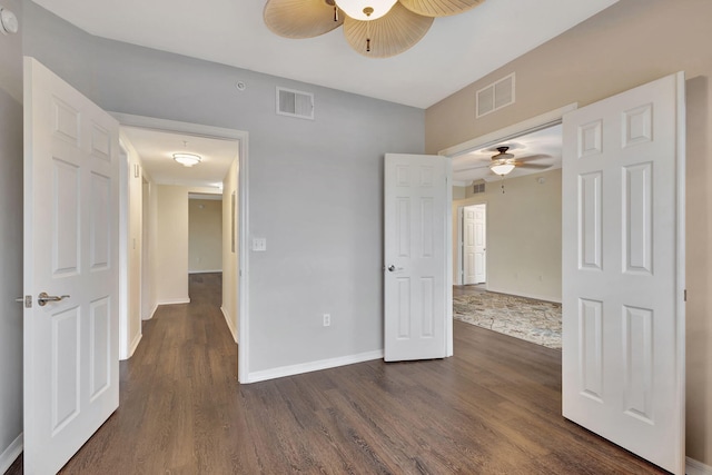 empty room featuring dark wood-type flooring and ceiling fan