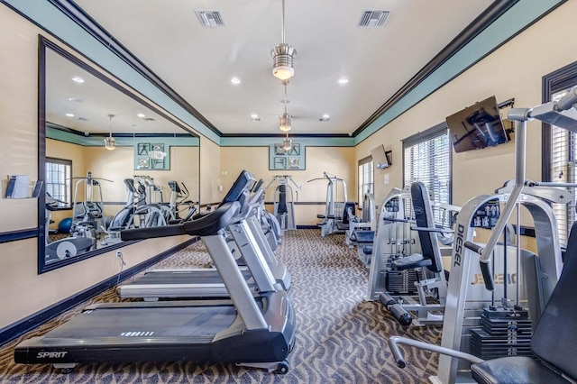 exercise room with dark carpet, ceiling fan, plenty of natural light, and crown molding