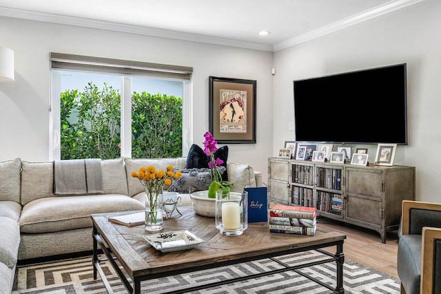 living room with crown molding, a wealth of natural light, and light hardwood / wood-style flooring