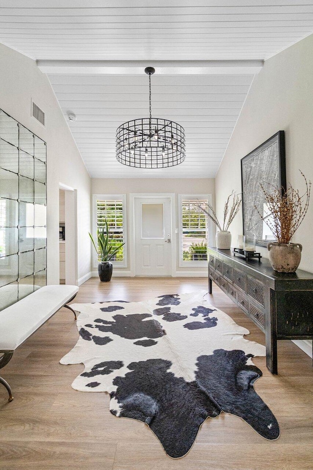 entryway with a wealth of natural light, light wood-type flooring, and lofted ceiling with beams