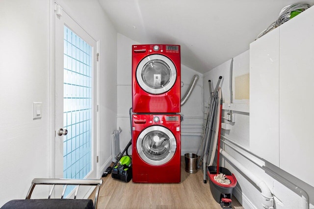 washroom with stacked washer / dryer and light hardwood / wood-style flooring