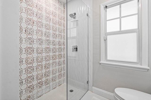 bathroom with tiled shower and toilet