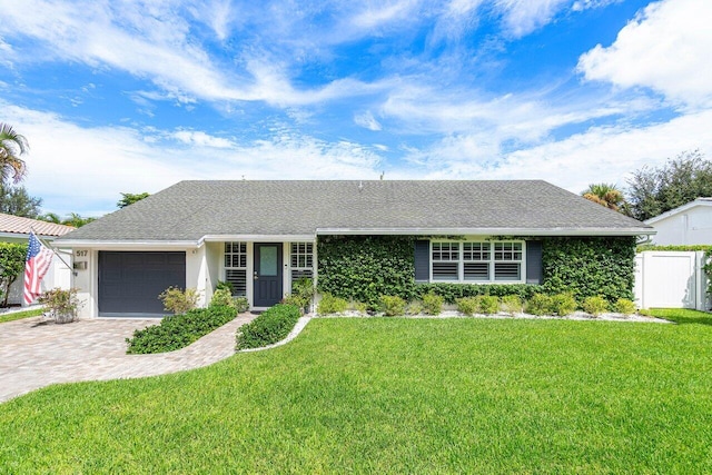 single story home featuring a garage and a front lawn