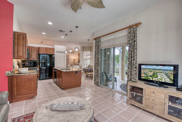 kitchen featuring black appliances, an island with sink, hanging light fixtures, and light tile patterned flooring