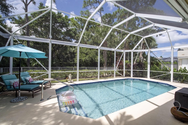 view of swimming pool with glass enclosure, a patio area, a fenced backyard, and a fenced in pool