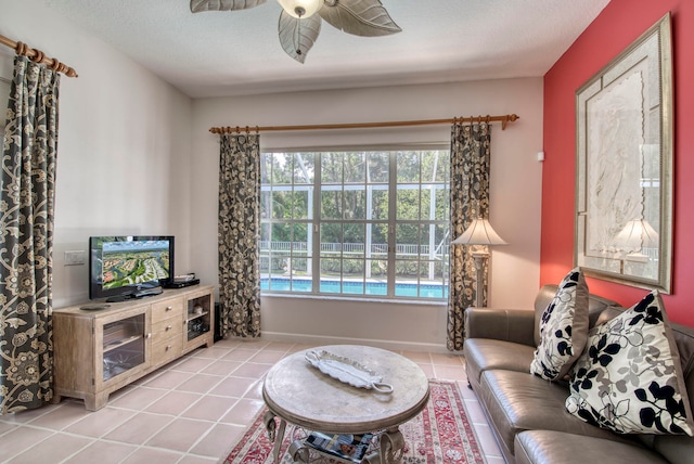 living room with ceiling fan, a textured ceiling, and light tile patterned floors